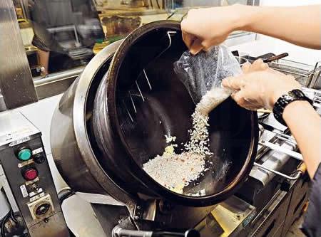 麵店的獨門炒飯機,放蛋和飯後,高溫極速炒飯,以攝氏 240 度將飯粒炒香,而其螺旋傾斜設計可減少炒飯時水份流失。(麵座)