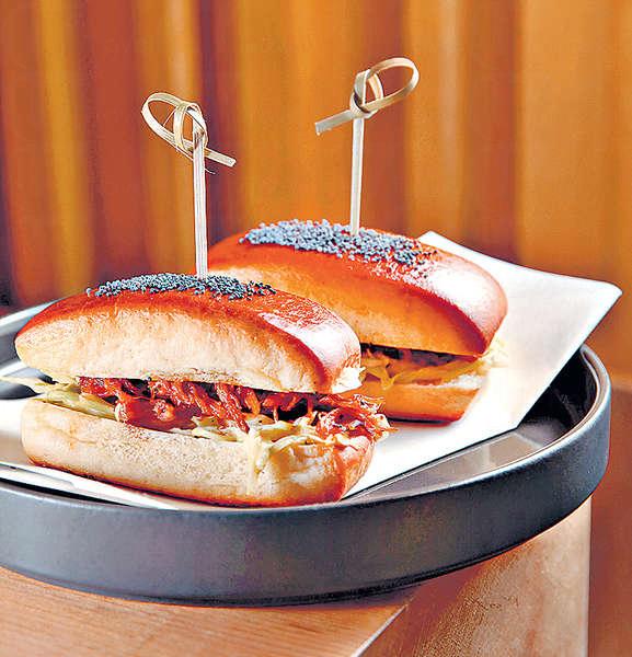 【Sloppy Joe $98】鬆軟的麵包表面灑有罌粟籽,夾入BBQ醬醃過的燒豬腿肉、洋蔥和椰菜絲,有點像漢堡包,卻帶點東方氣息。